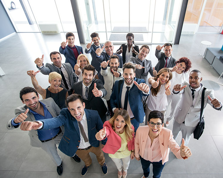 group of professional smiling at camera above and giving thumbs up