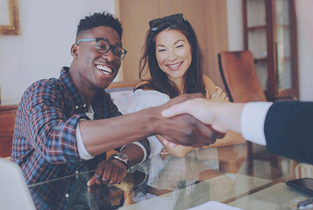 couple shaking hands with a professional mortgage banker